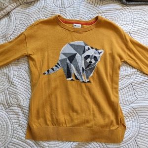 yellow sweater with a graphic geometric raccoon design